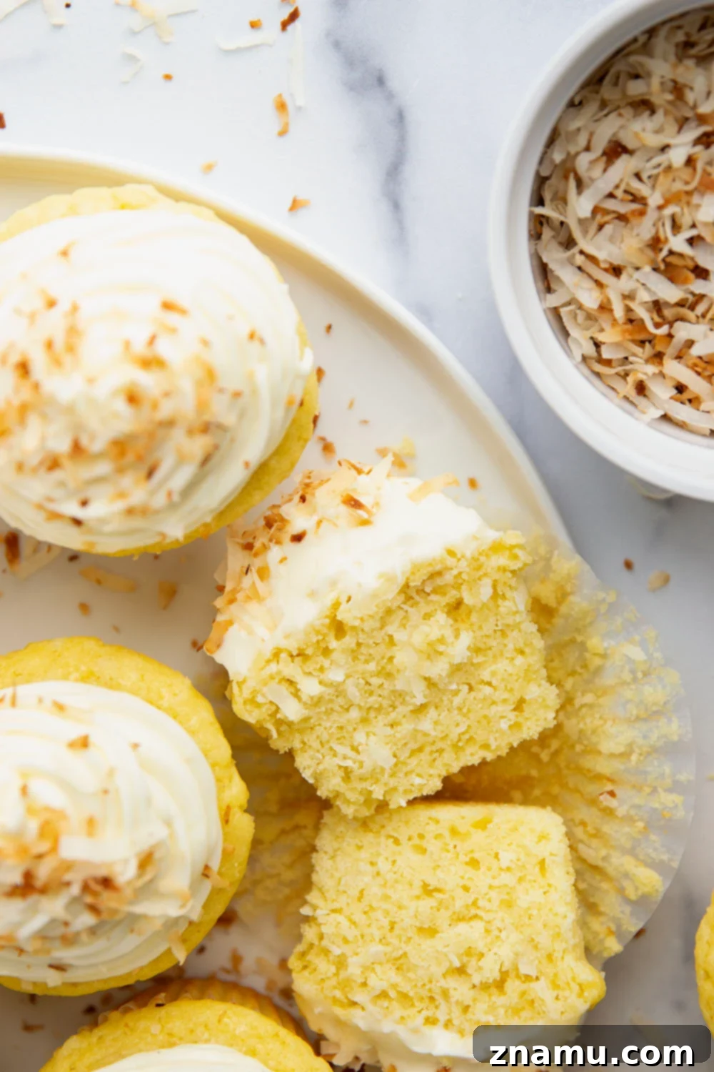 Heavenly Coconut Cupcakes with Cream Cheese Frosting 6 A beautifully decorated coconut cupcake with cream cheese frosting and toasted coconut