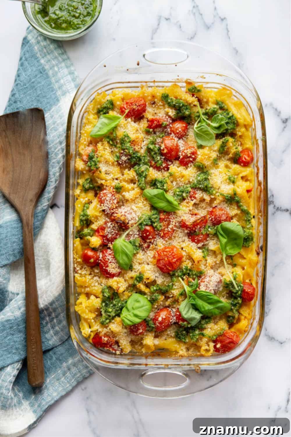 Vibrant Macaroni and Cheese: Bursting Tomatoes & Aromatic Basil Pesto 6 A serving of Bursting Tomato Macaroni and Cheese with basil pesto drizzled on top, ready to eat.