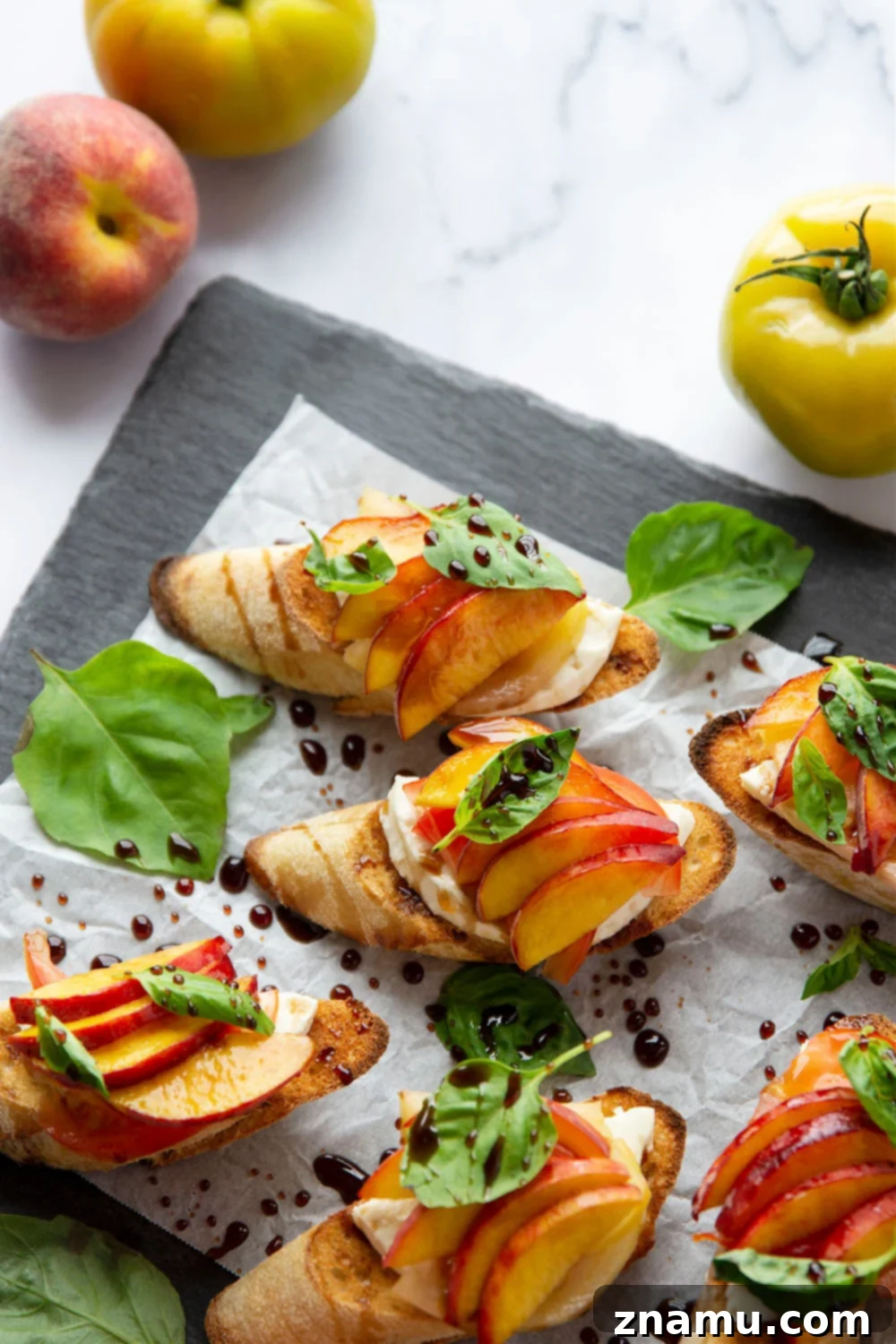Golden Peach Caprese Toasts 4 Close-up of Caprese Peach Bruschetta showcasing a slice of fresh mozzarella, ripe peach, and tomato on toasted bread.