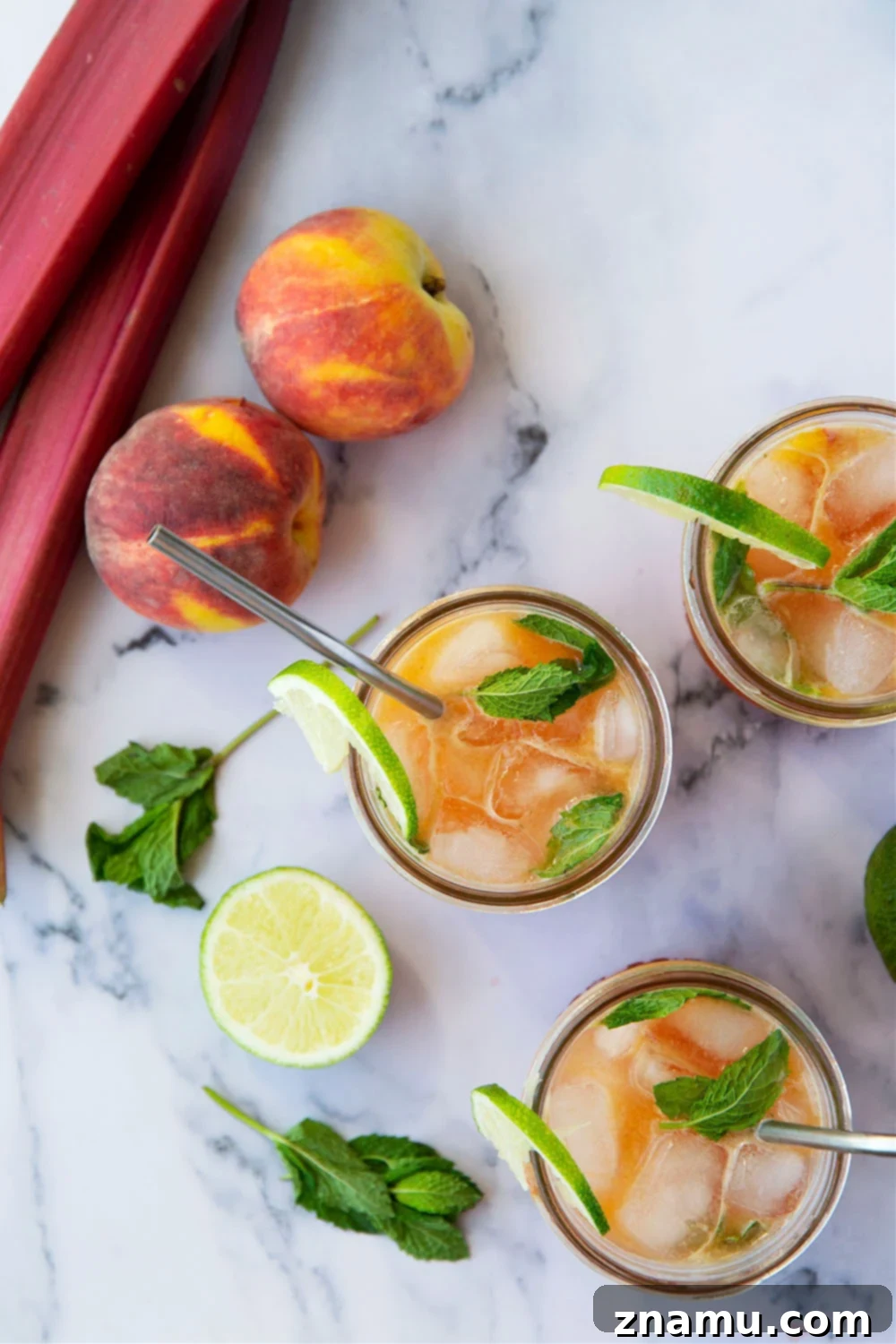 Rhubarb Peach Bourbon Elixir 6 A selection of Rhubarb Peach Bourbon Smashes ready to be served, showcasing their vibrant color and fresh garnishes.