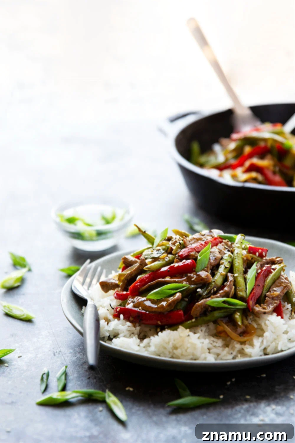 Sticky Ginger-Black Pepper Beef 5 Assortment of fresh ingredients for black pepper beef, including sliced beef, vegetables, ginger, and garlic, laid out on a cutting board.