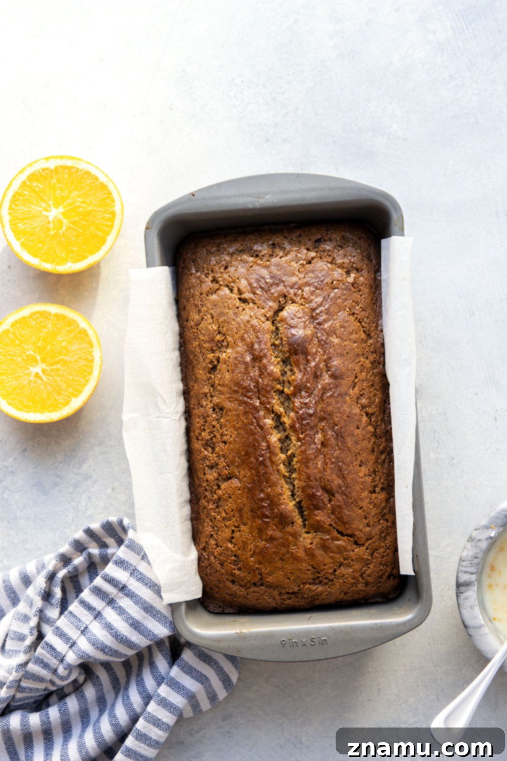 Cozy Gingerbread Loaf with Zesty Orange Glaze 3 Close-up of a slice of moist gingerbread loaf cake topped with creamy orange icing.