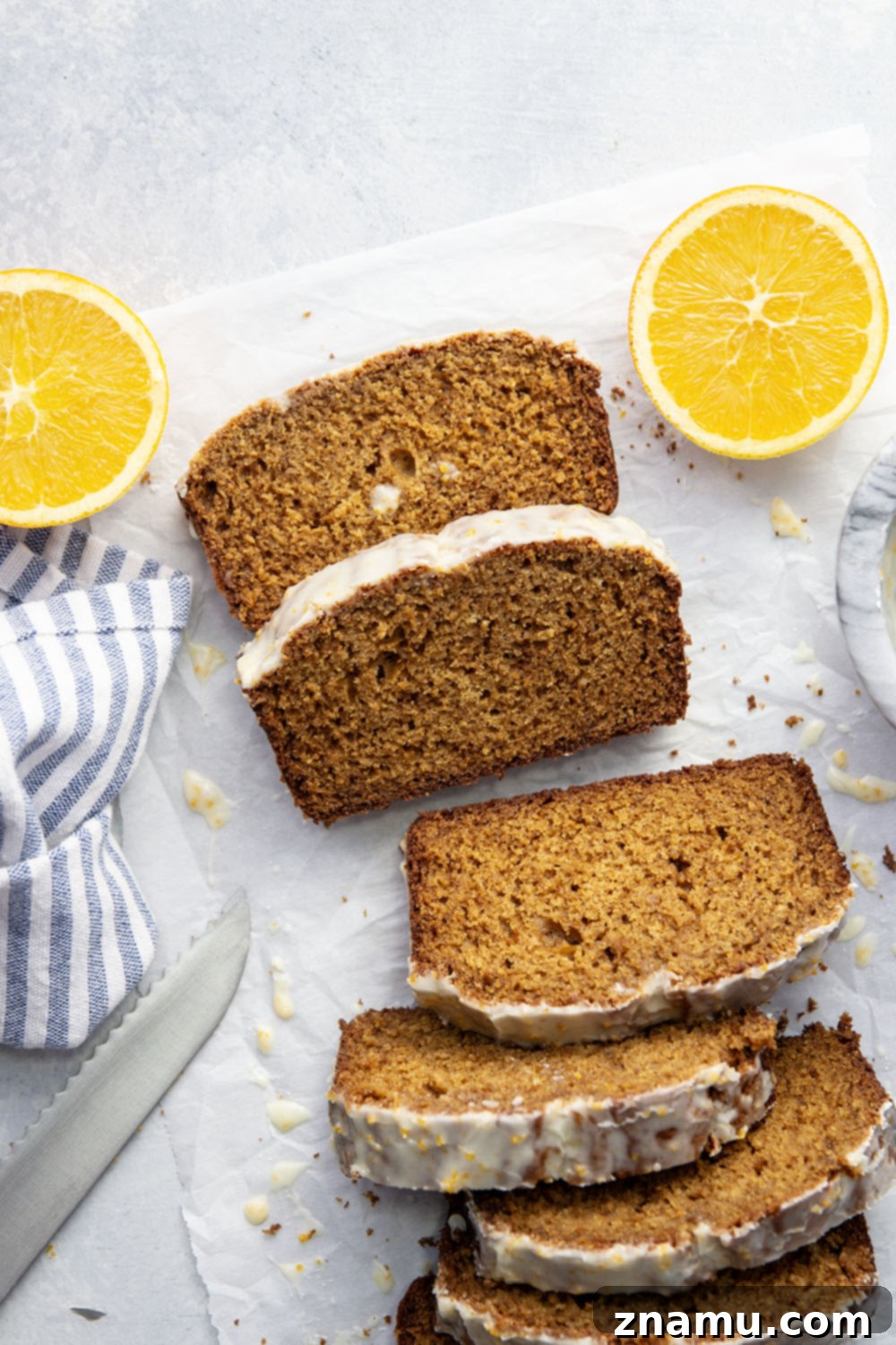 Cozy Gingerbread Loaf with Zesty Orange Glaze 6 A large slice of gingerbread loaf cake with orange icing, ready to be served.