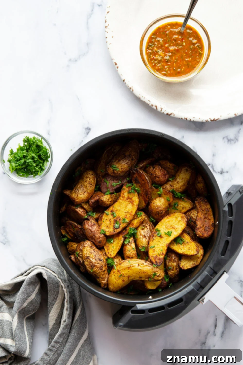 Crispy Air Fryer Fingerling Potatoes with Zesty Harissa Chimichurri 5 Air fryer fingerling potatoes drizzled with harissa chimichurri sauce in a serving bowl.