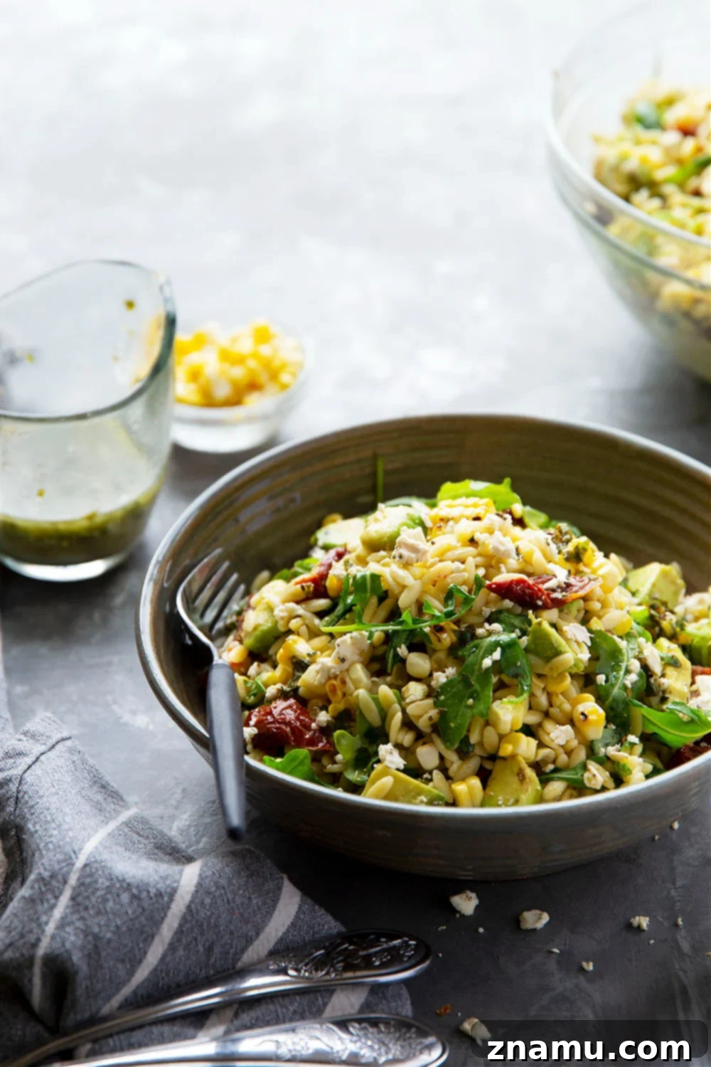 Smoky Corn & Sun-Kissed Tomato Orzo Salad 6 Eye-level view of a plated sun-dried tomato orzo salad, showing depth and texture.
