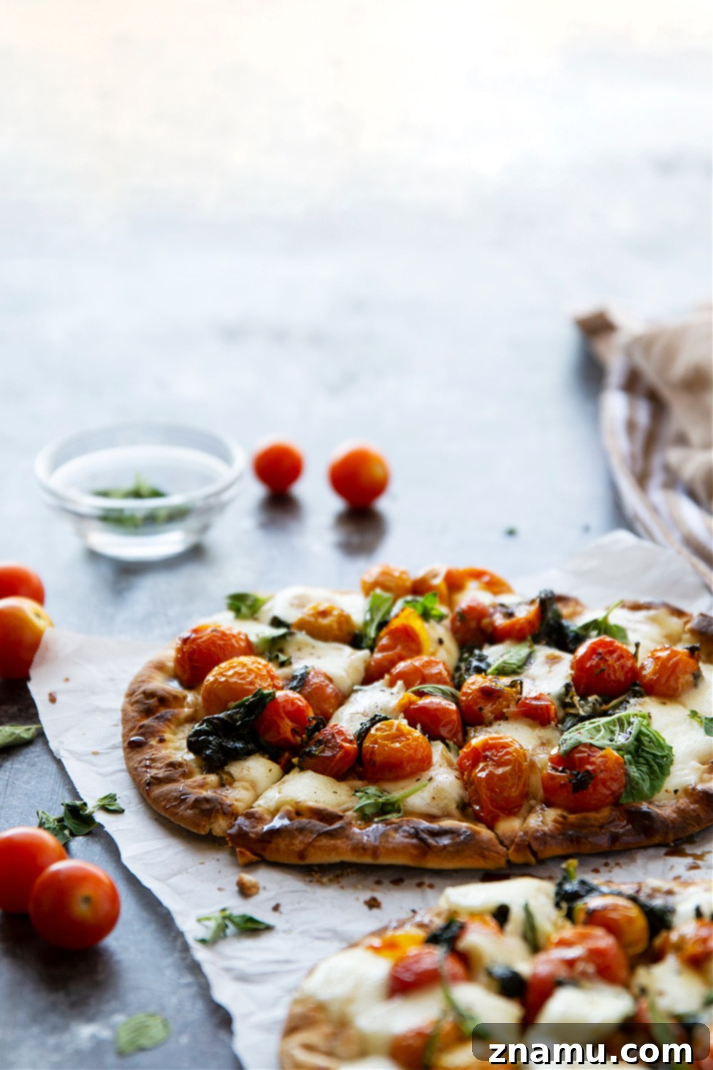 Creamy Burrata Flatbread with Burst Tomatoes and Spinach 5 Ingredients for bursting tomato flatbread laid out, including fresh tomatoes, herbs, and cheese.