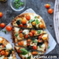 Creamy Burrata Flatbread with Burst Tomatoes and Spinach 8 Finished bursting tomato flatbread, cut into slices.