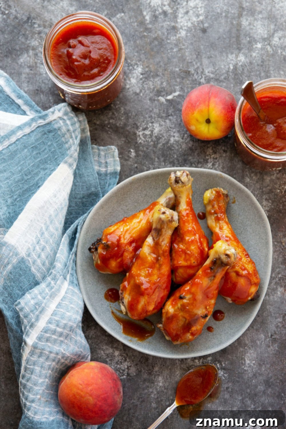 Sweet Heat Peach Chipotle Glaze 4 Ingredients for Chipotle Peach BBQ Sauce laid out on a kitchen counter, including fresh peaches and chipotle peppers.