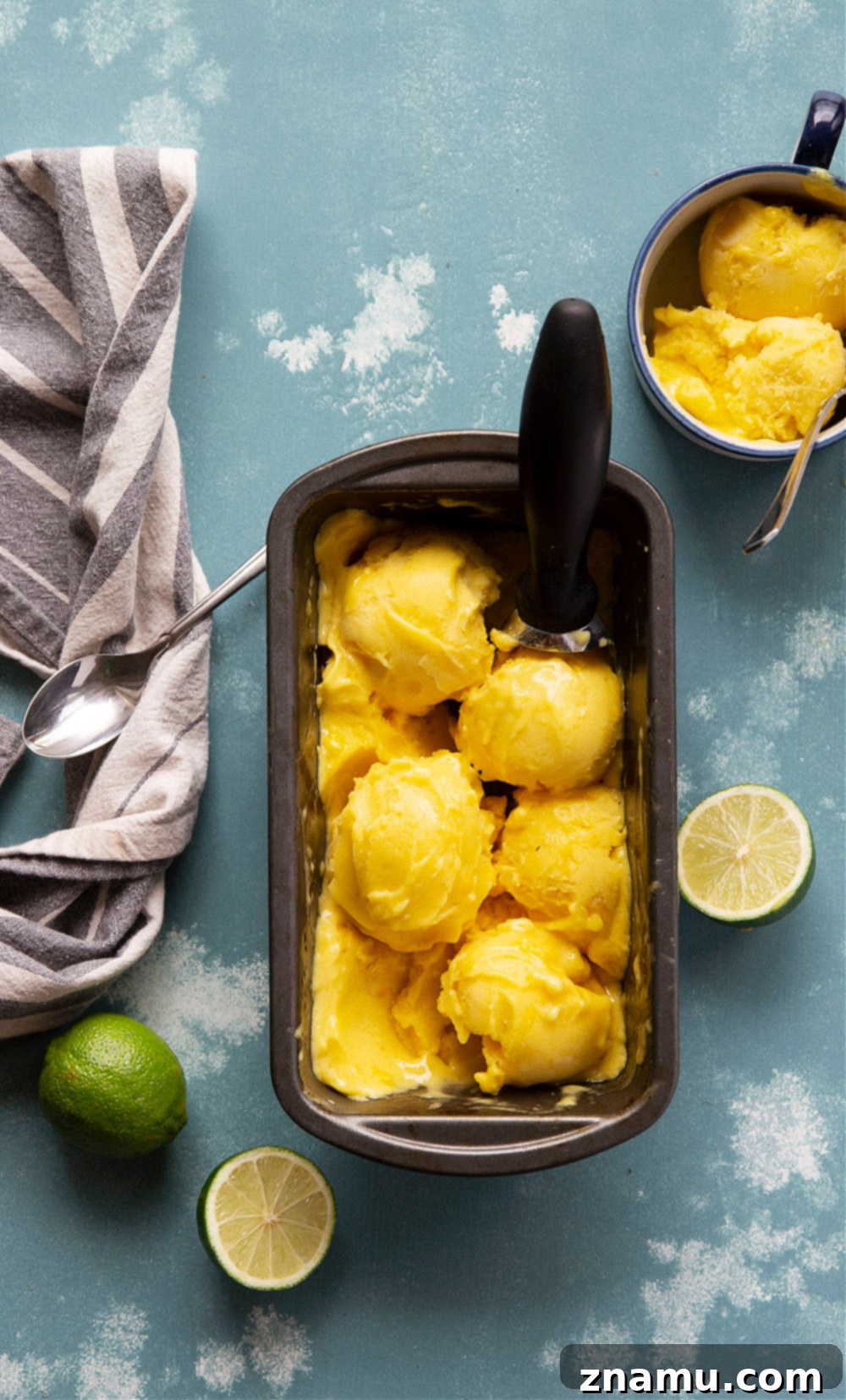 Tropical No Churn Mango Pineapple Sorbet 6 Scoops of creamy mango pineapple sorbet in a bowl, garnished with fresh mint.