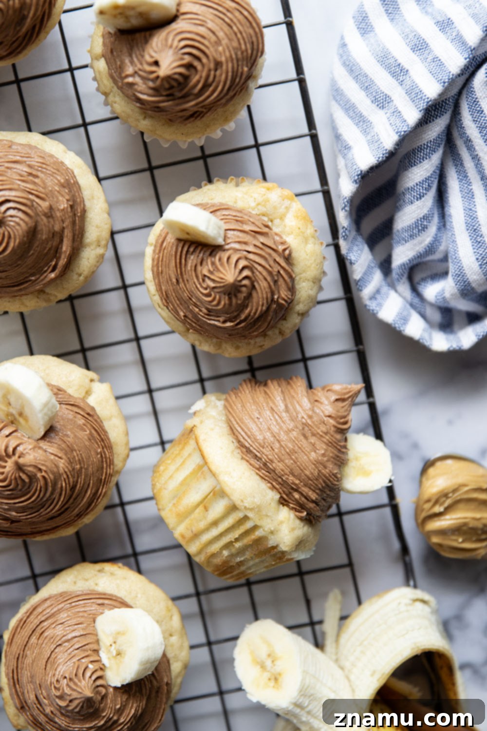 Rich Banana Cupcakes with Decadent Chocolate Peanut Butter Frosting 4 Freshly baked banana cupcakes cooling on a rack
