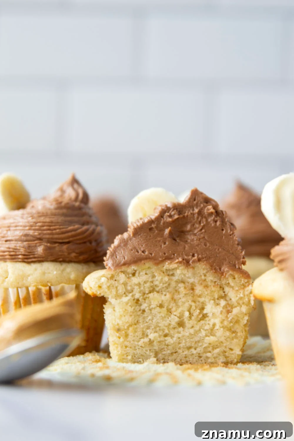 Rich Banana Cupcakes with Decadent Chocolate Peanut Butter Frosting 6 A plate of banana cupcakes with chocolate peanut butter frosting, garnished with banana slices