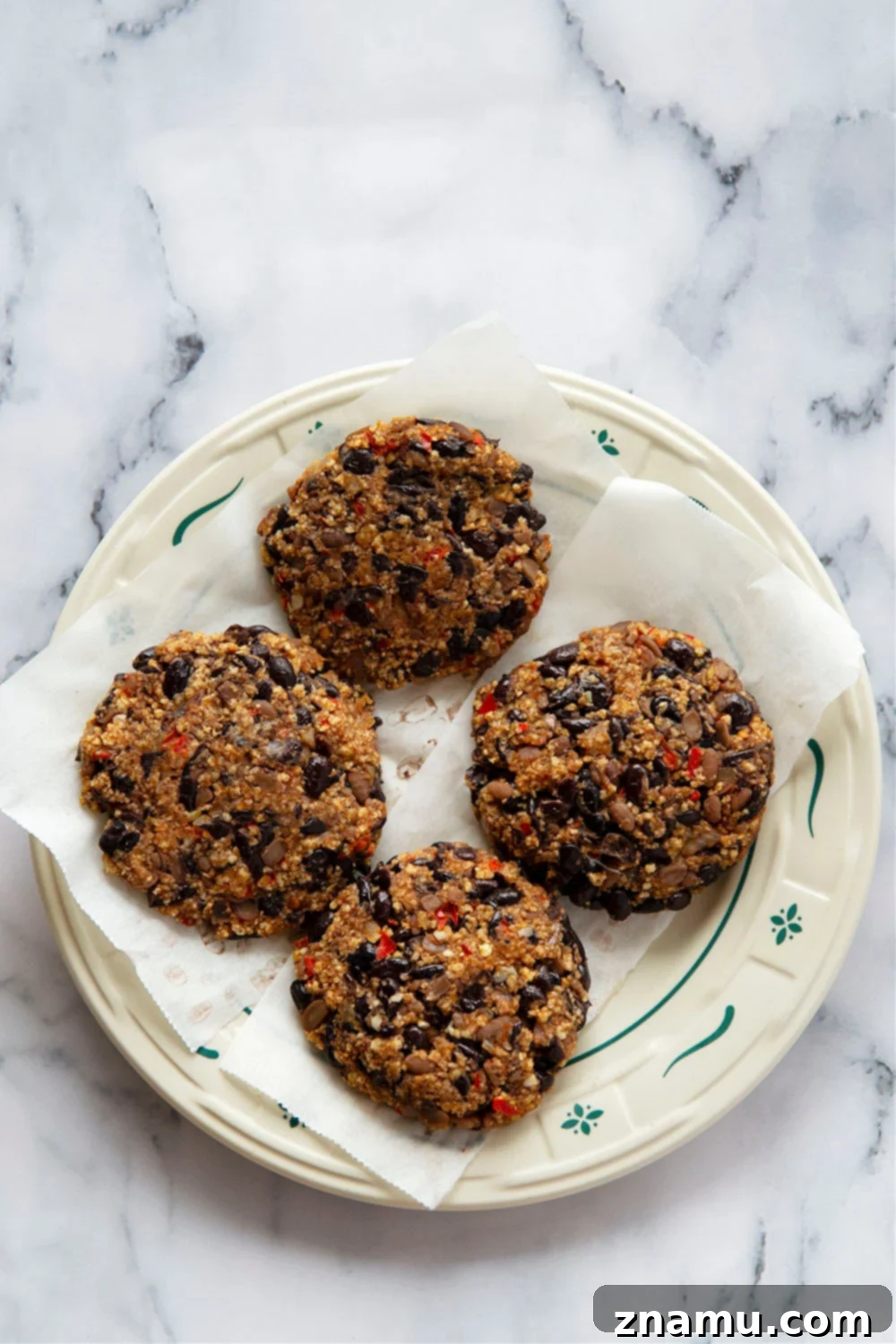 A plate of freshly prepared ingredients for air fryer black bean burgers, including black beans, peppers, onions, and spices.