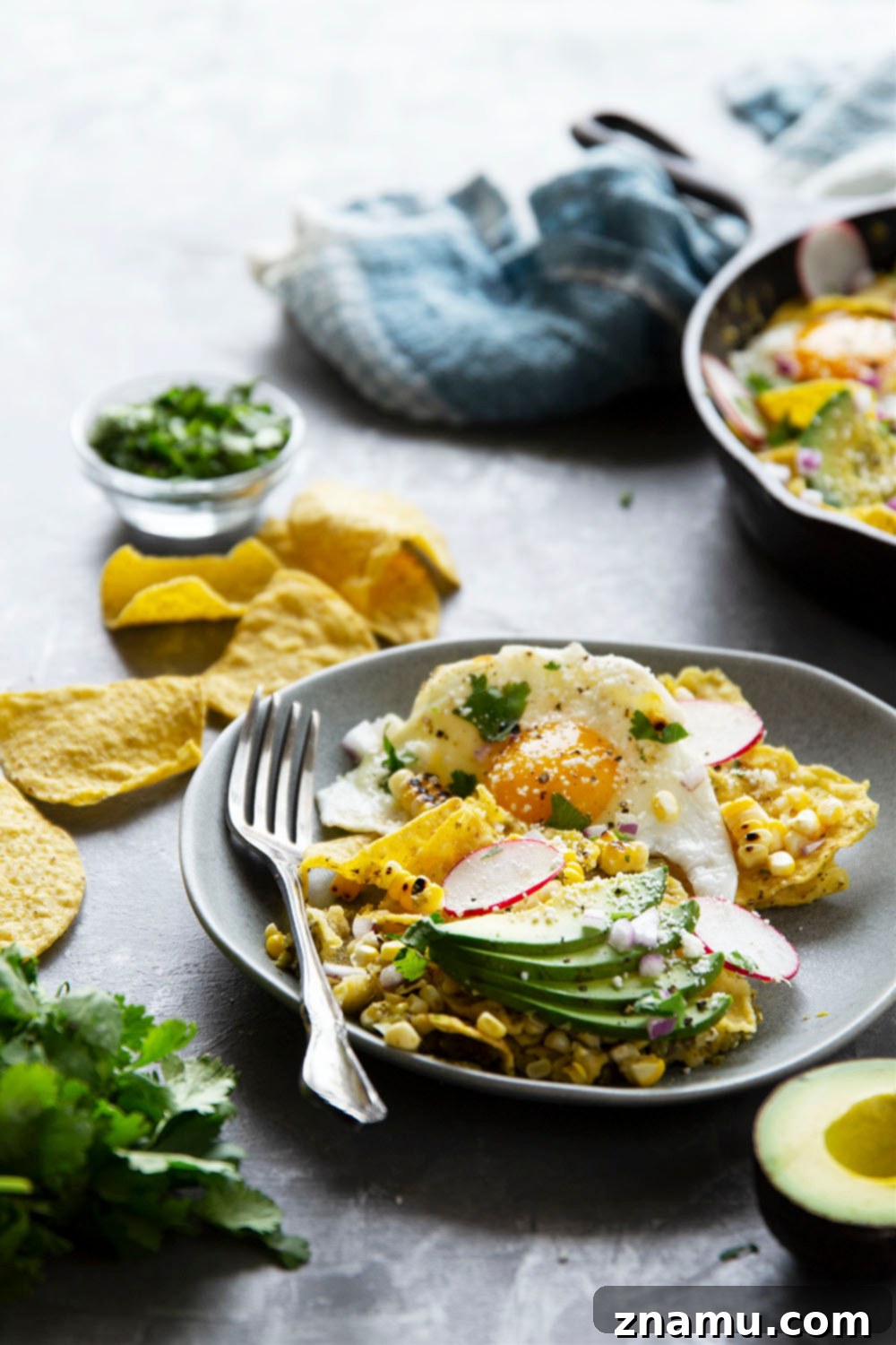 Chilaquiles Verdes served directly in the skillet, showcasing the generous toppings and vibrant colors.