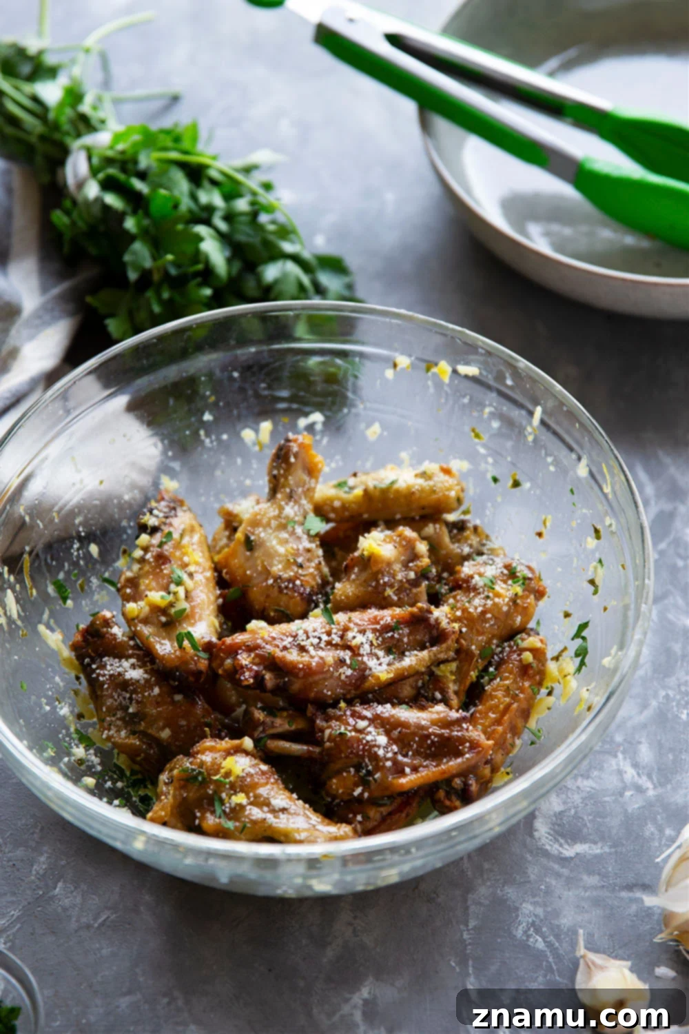 Crispy Air Fryer Lemon Garlic Wings 4 Fresh ingredients laid out for lemon garlic chicken wings: lemons, garlic cloves, parsley, and butter.