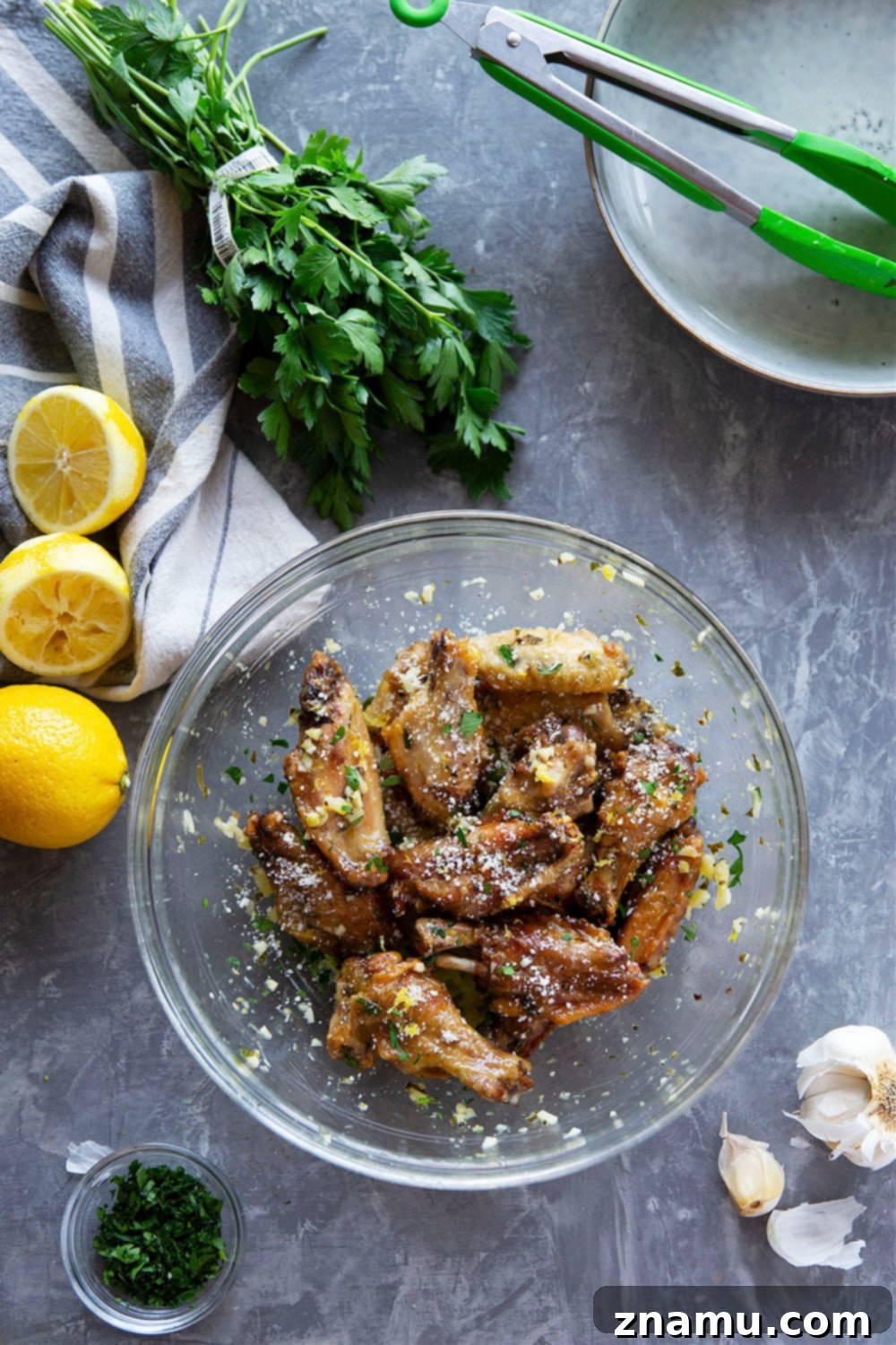 Crispy Air Fryer Lemon Garlic Wings 6 A large platter of golden, crispy air fryer lemon garlic chicken wings, garnished with fresh parsley.