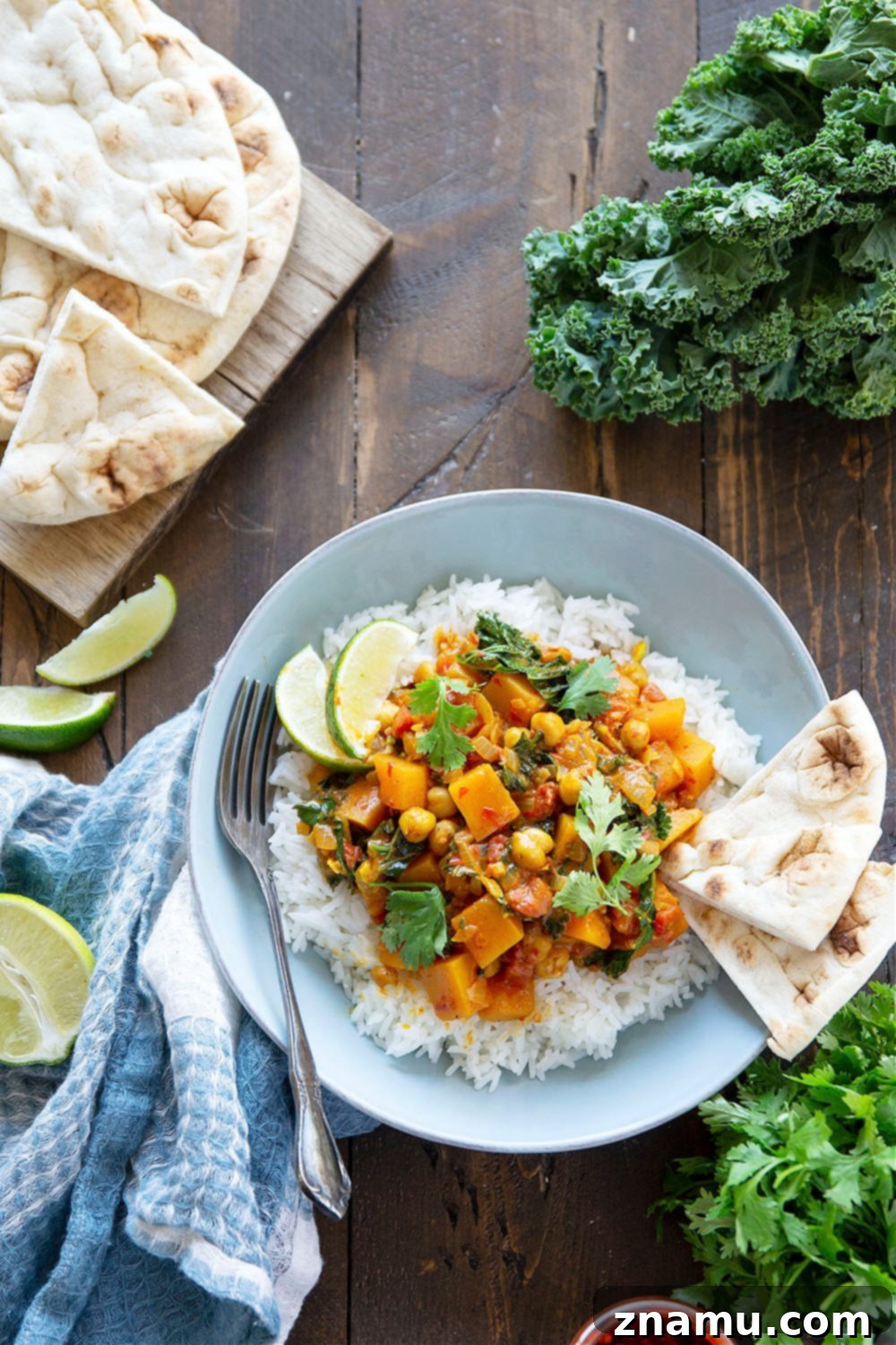 Harissa Spiced Butternut Squash Chickpea Pot 4 A top-down view of the Harissa Chickpea Butternut Squash Curry in a large pot, ready to be served. Highlights the vibrant colors of squash and kale.