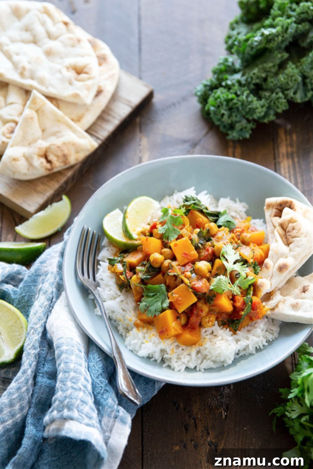 Harissa Spiced Butternut Squash Chickpea Pot 6 A person holding a bowl of Harissa Chickpea Butternut Squash Curry, ready to enjoy. Emphasizes the comforting and hearty nature of the meal.