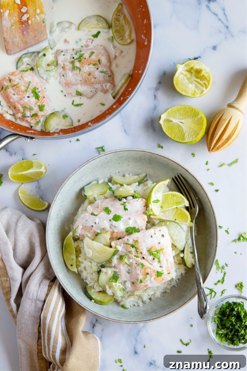 Creamy Coconut Salmon Skillet 4 Individual serving of coconut milk salmon with rice, lime, and cilantro on a plate.