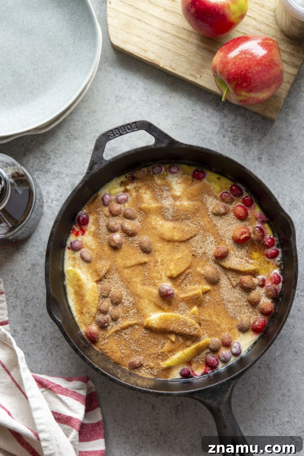 Puffed Cranberry Apple Dutch Baby 3 Close-up of a Cranberry Apple Dutch Baby in a cast iron skillet, showing the fluffy texture and vibrant fruit, making a perfect fall breakfast.