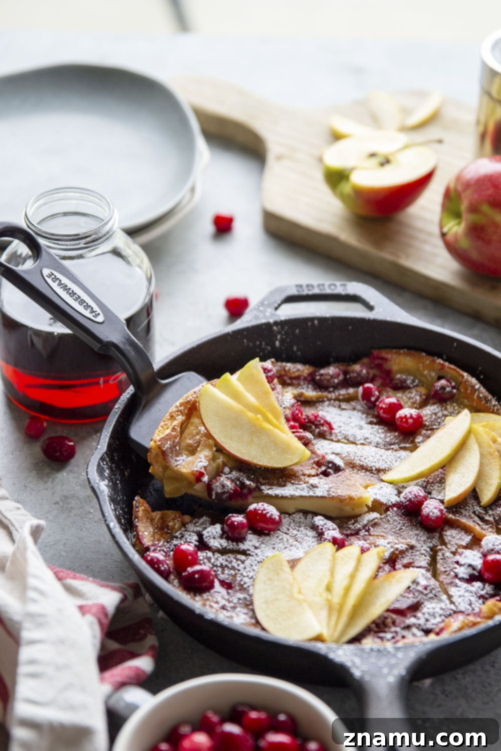 Puffed Cranberry Apple Dutch Baby 5 A cast iron skillet generously buttered and ready for the Cranberry Apple Dutch Baby batter, emphasizing the importance of pan preparation.
