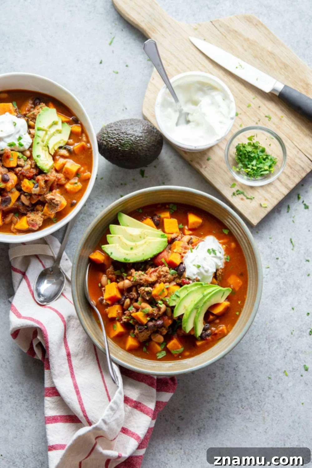 Bold Chipotle Chicken Sweet Potato Chili 6 Overhead shot of a bowl of Chipotle Chicken Sweet Potato Chili, garnished with sour cream, green onions, and fresh cilantro, ready to be enjoyed.