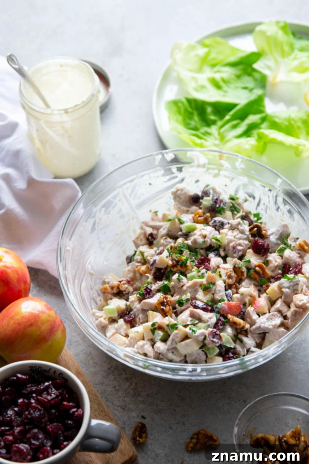 Gourmet Cranberry Apple Chicken Salad 4 A bowl of cranberry apple chicken salad featuring fresh parsley and thyme as garnishes.