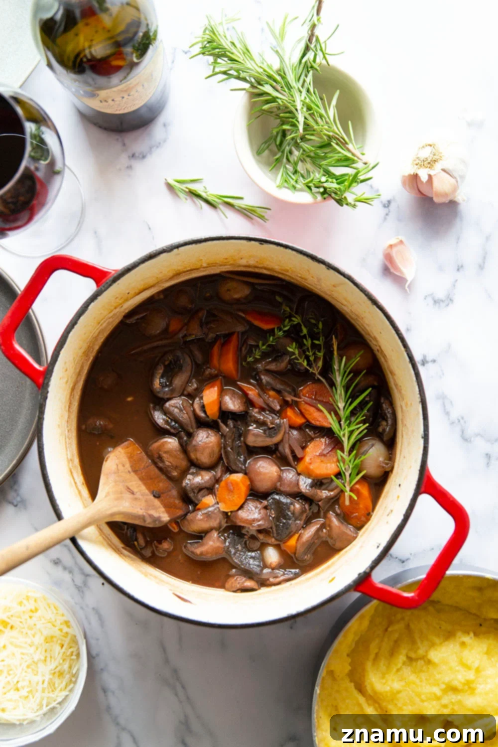 Hearty Mushroom Bourguignon with Velvety Asiago Polenta 3 Mushroom bourguignon features a savory red wine mushroom sauce served on top of creamy asiago polenta.