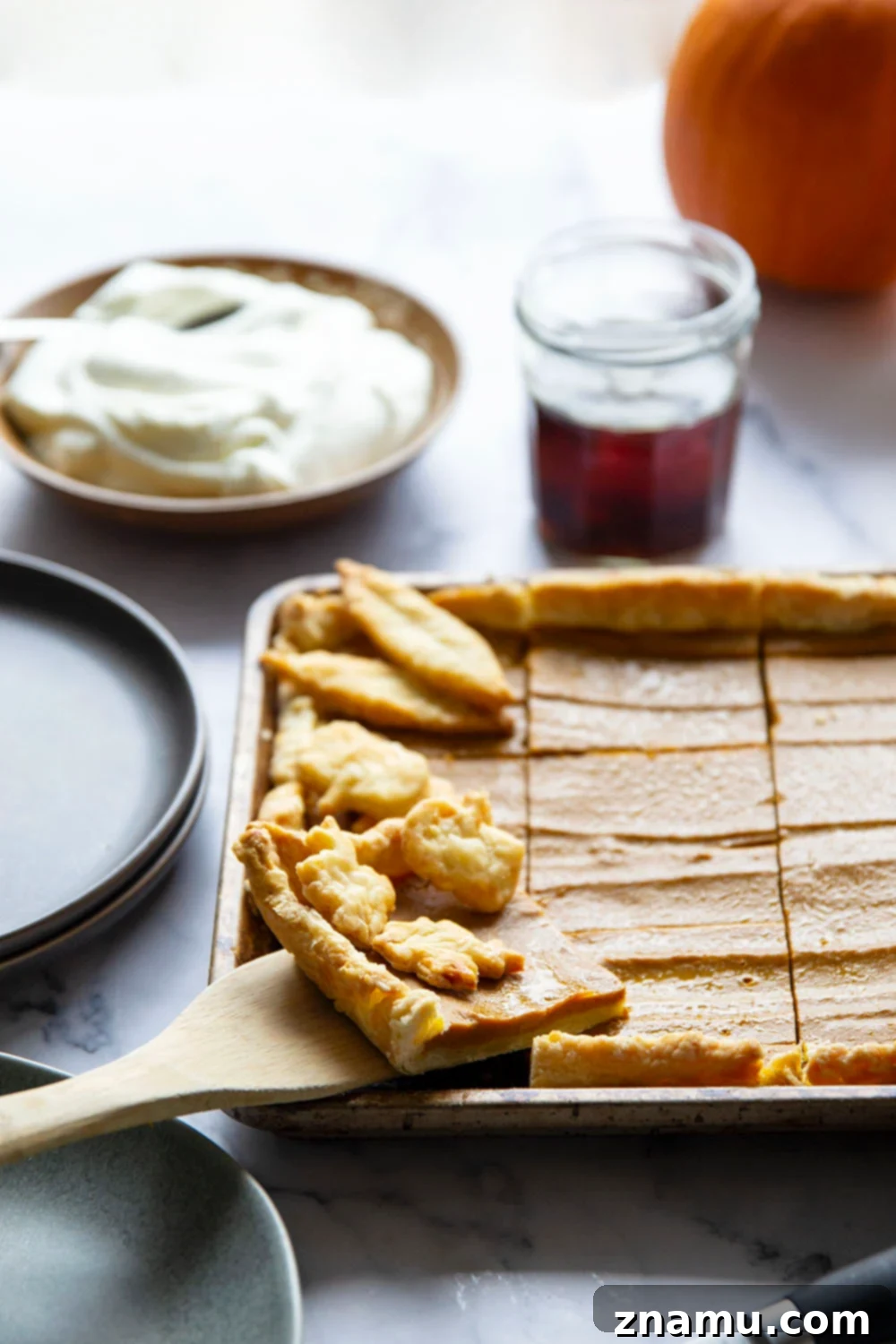 Easy Sheet Pan Pumpkin Pie Bars 4 A close-up of a slice of Sheet Pan Pumpkin Pie showcasing its golden-brown, flaky crust and smooth, spiced pumpkin filling.