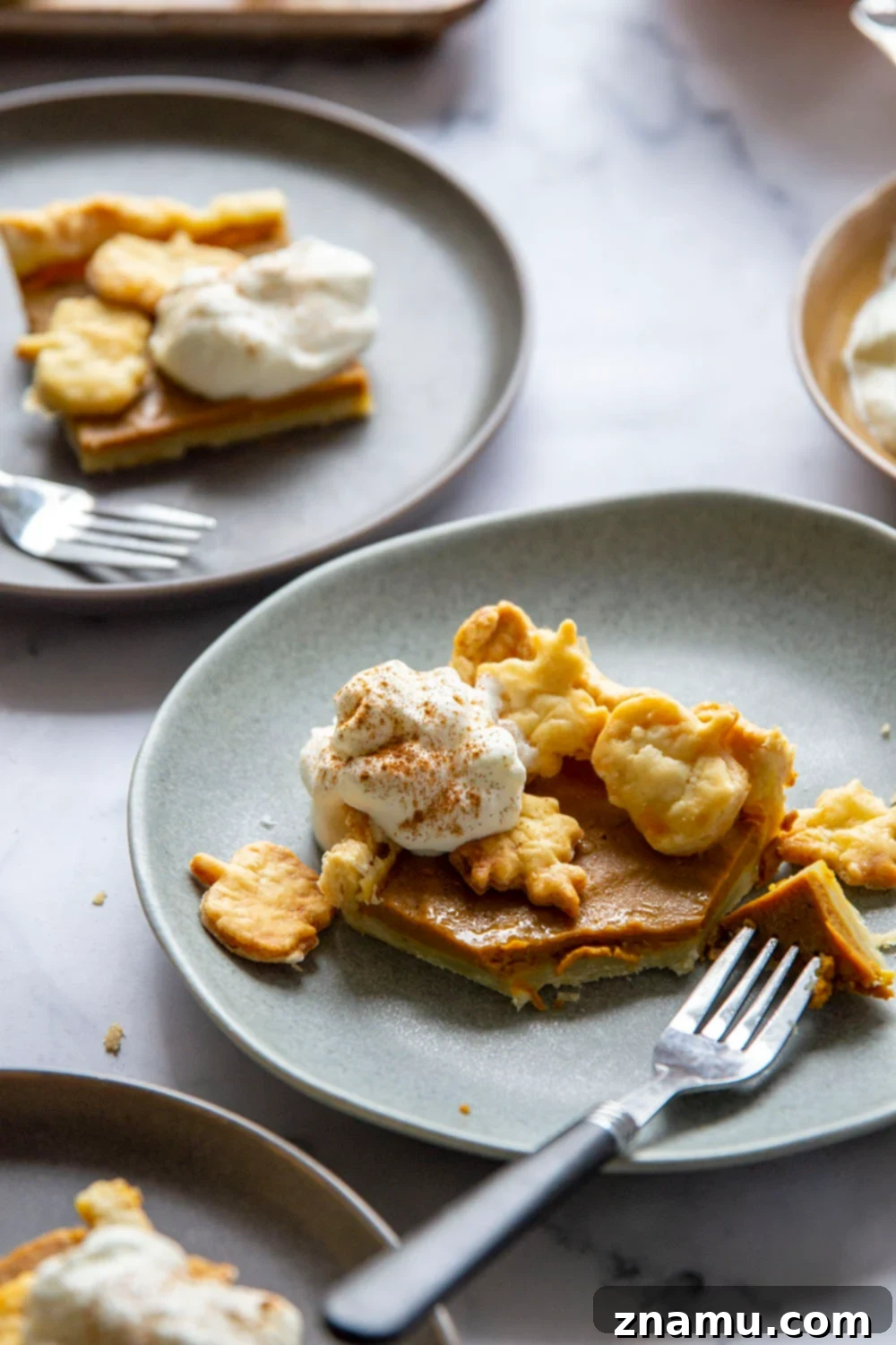 Easy Sheet Pan Pumpkin Pie Bars 6 A large Sheet Pan Pumpkin Pie with decorative leaf cutouts, ready to be sliced and served at a festive gathering.