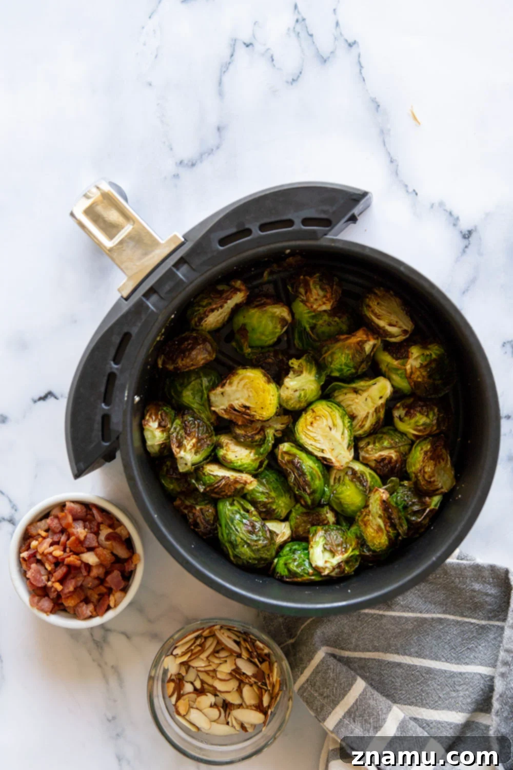 Blistered Air Fryer Brussels Sprouts with Hot Honey Butter 3 A close-up shot of golden-brown air-fried Brussels sprouts with visible hot honey glaze and crispy edges.