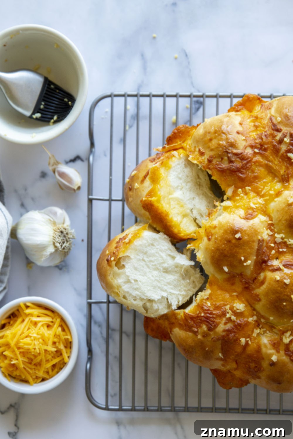 Skillet Garlic Cheddar Dinner Rolls 6 A close-up of several Garlic Cheddar Skillet Dinner Rolls with a rich, golden crust and melted cheese.