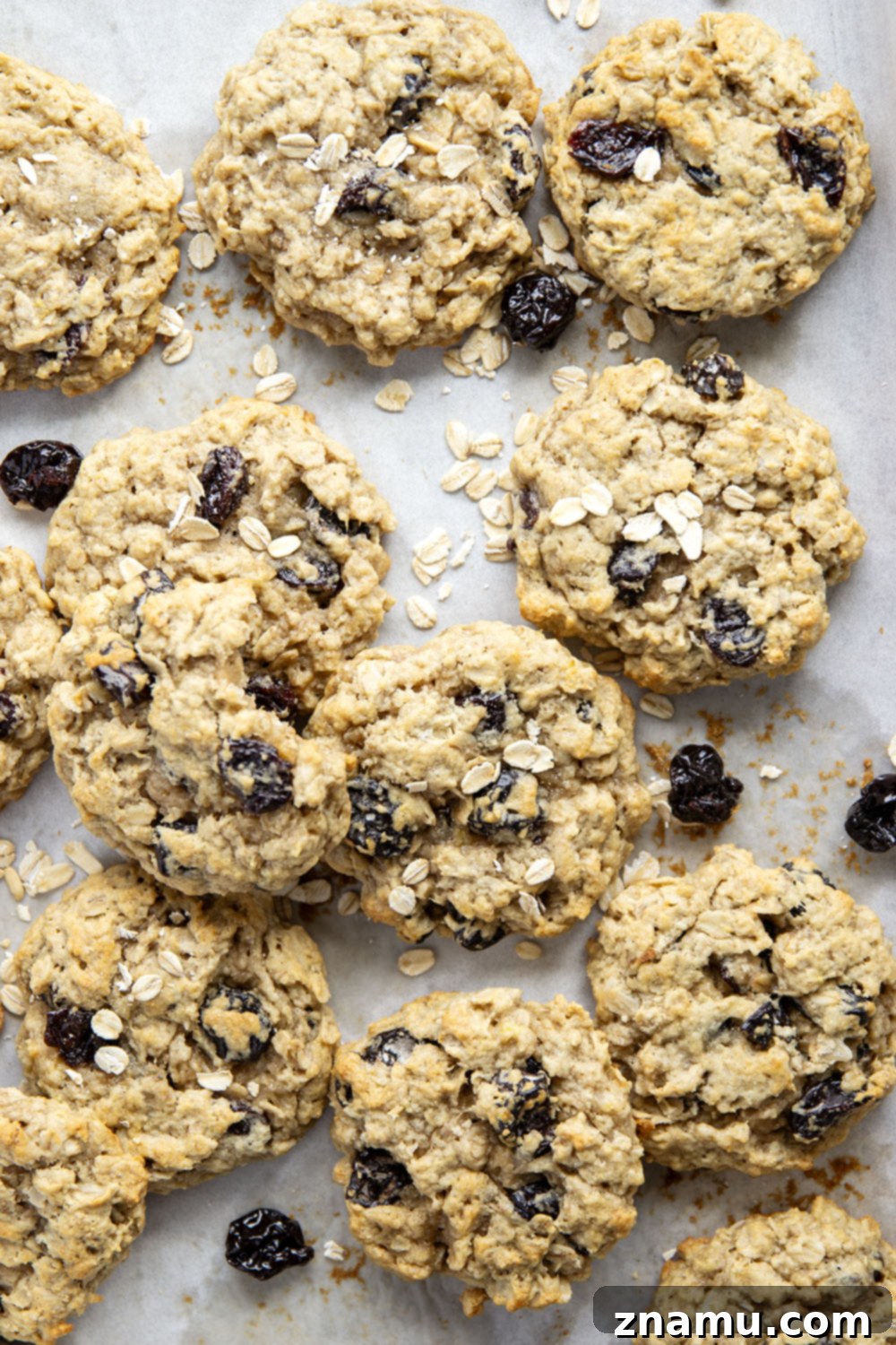 Delicious Banana Cherry Oatmeal Cookies 6 A stack of banana cherry oatmeal cookies, perfectly golden and appealing, with a glass of milk in the background, ready to be enjoyed.