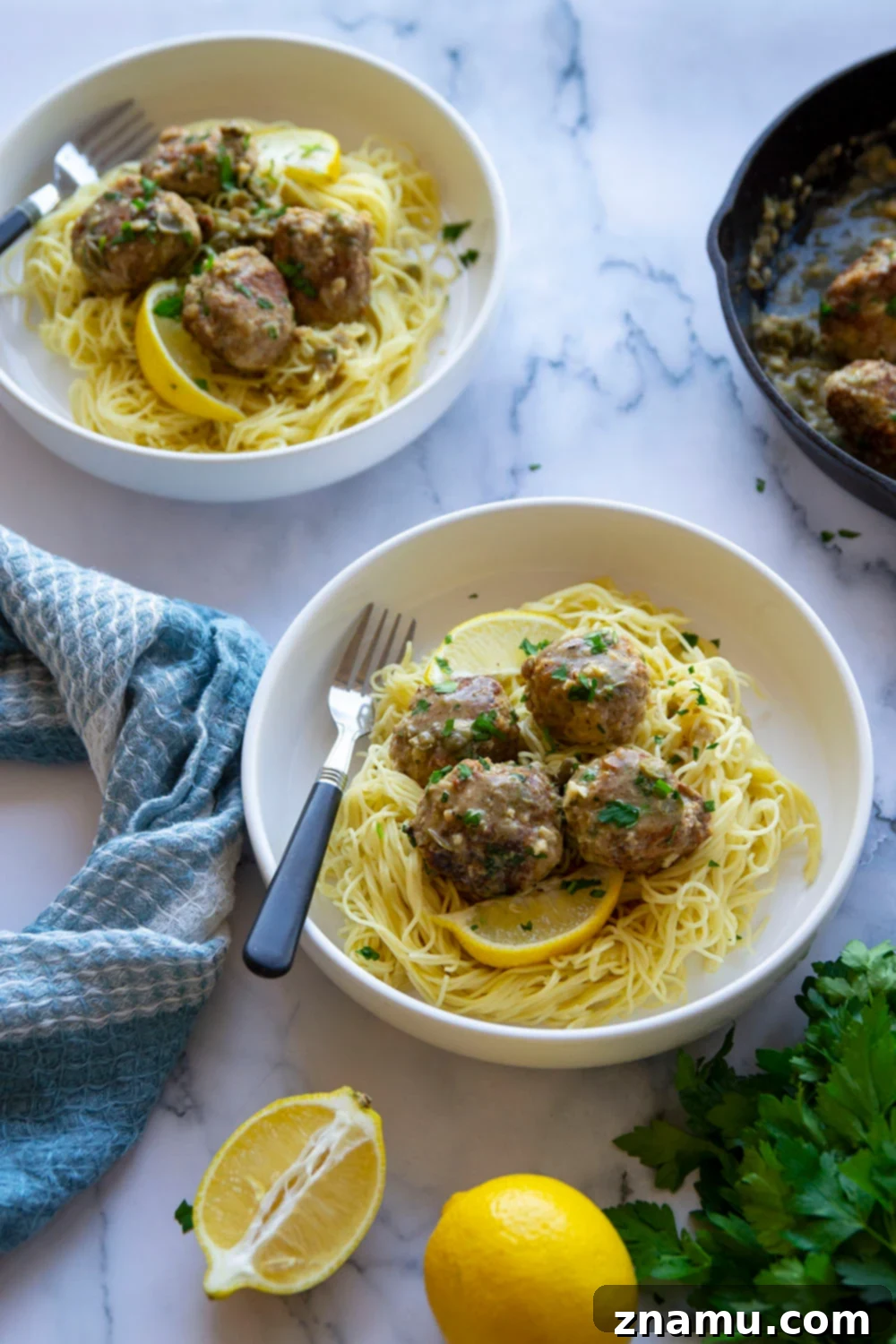 Piccata-Style Chicken Meatballs 5 A generous serving of chicken piccata meatballs and lemon caper sauce on a bed of angel hair pasta, garnished with fresh parsley
