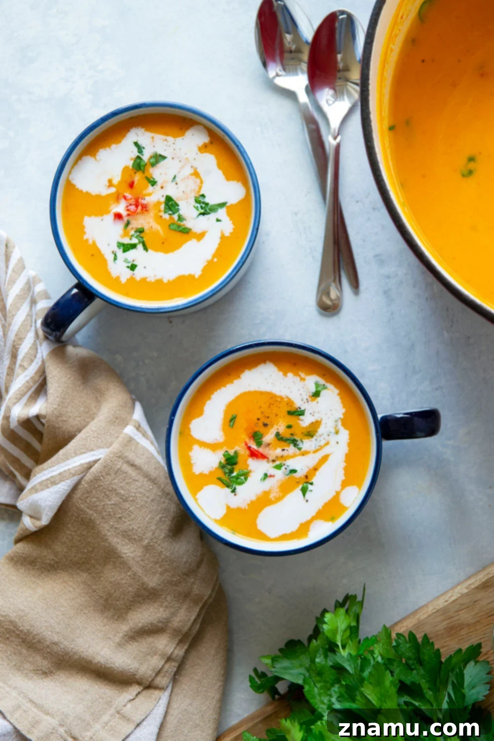 Sweet & Smoky Butternut Squash Soup with Coconut 3 Close-up of creamy butternut squash soup in a bowl with a spoon.