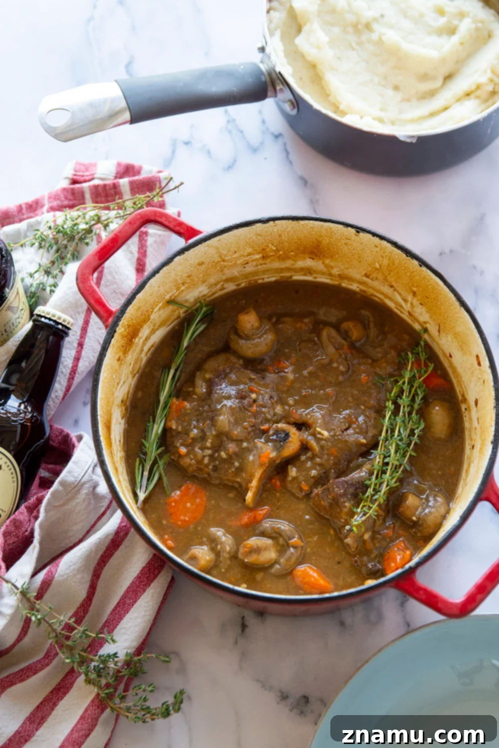 Guinness Braised Beef with Brown Butter Whipped Potatoes 5 A Dutch oven filled with prepared Guinness pot roast, showcasing the tender beef, robust vegetables, and rich gravy, ready to be served.