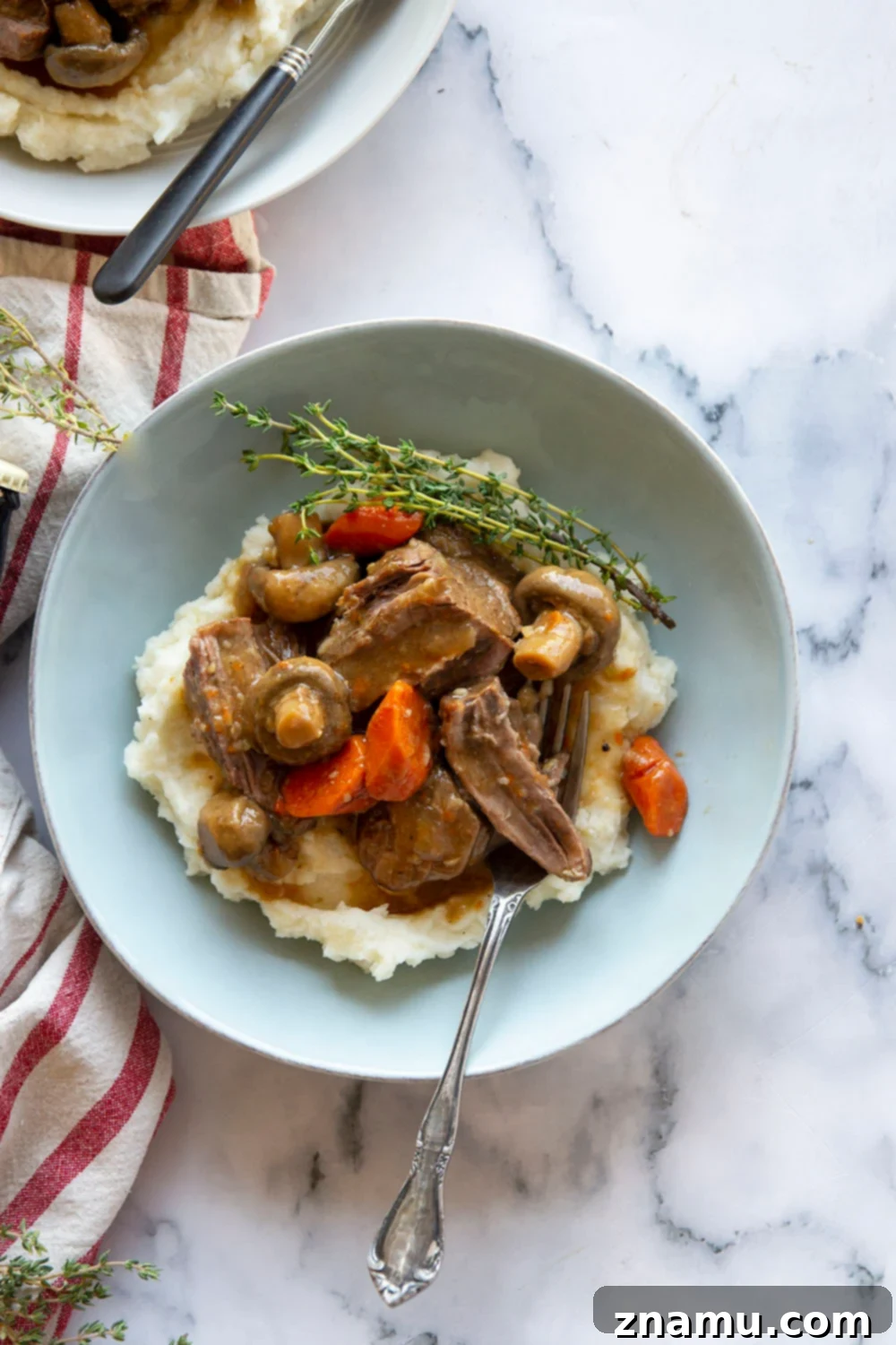 Guinness Braised Beef with Brown Butter Whipped Potatoes 6 A generous serving of Guinness pot roast with browned butter mashed potatoes, presented on a plate ready to be enjoyed.