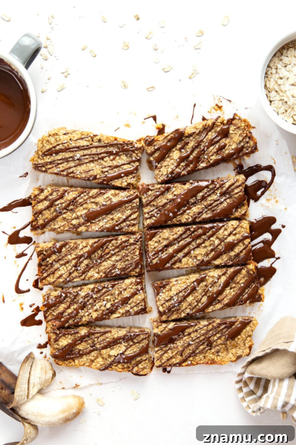 Chewy Peanut Butter Banana Oatmeal Bars 2 Freshly baked gluten-free peanut butter banana oat bars with chocolate drizzle, arranged on a cooling rack.