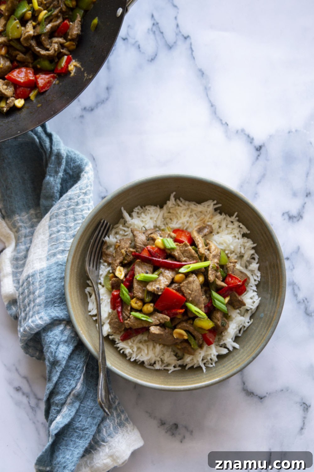 Szechuan Chili Peanut Beef 4 Ingredients for Kung Pao Beef laid out on a cutting board, including beef strips, bell peppers, green onions, dried chili peppers, and peanuts.