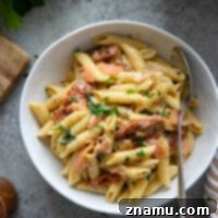 Smoky Salmon Sun-Kissed Tomato Pasta 8 A delightful bowl of Sun-Dried Tomato Smoked Salmon Pasta, presented as the final dish.