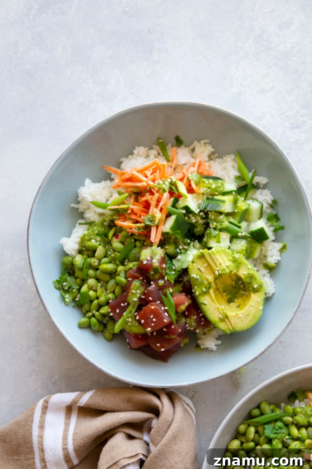 Spicy Green Curry Tuna Poke Bowls 4 Ingredients for spicy tuna poke bowls artfully arranged, including diced ahi tuna, cucumber, and green curry sauce components.