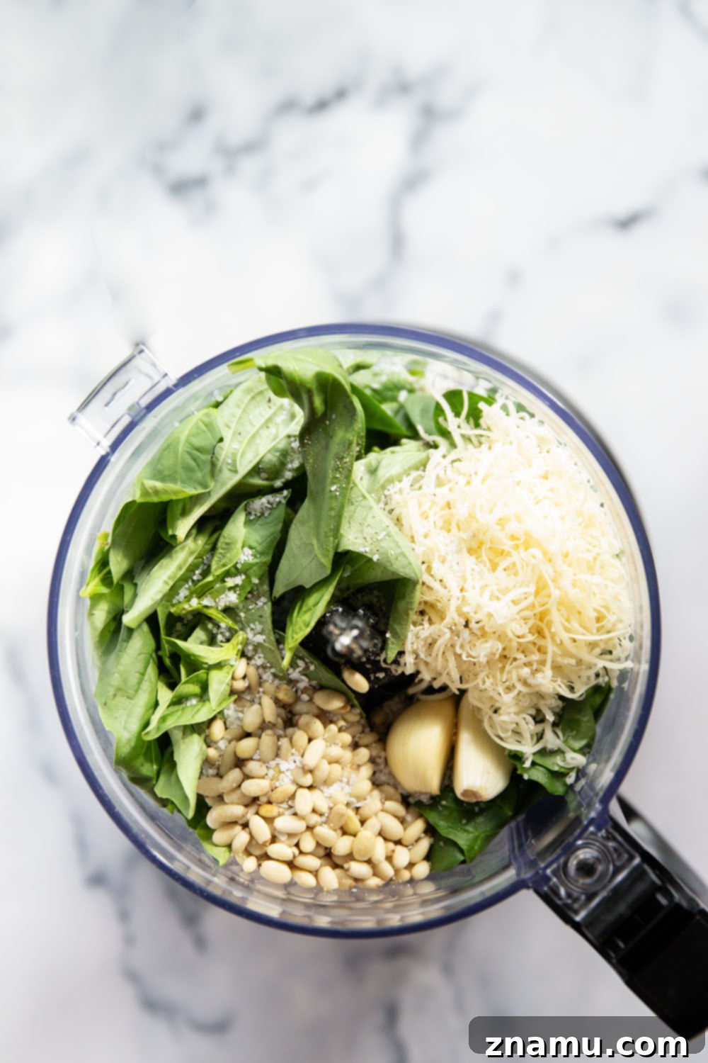 Emerald Spinach Basil Pesto 3 A wooden spoon scooping a portion of rich green spinach basil pesto from a rustic bowl, showcasing its smooth texture.