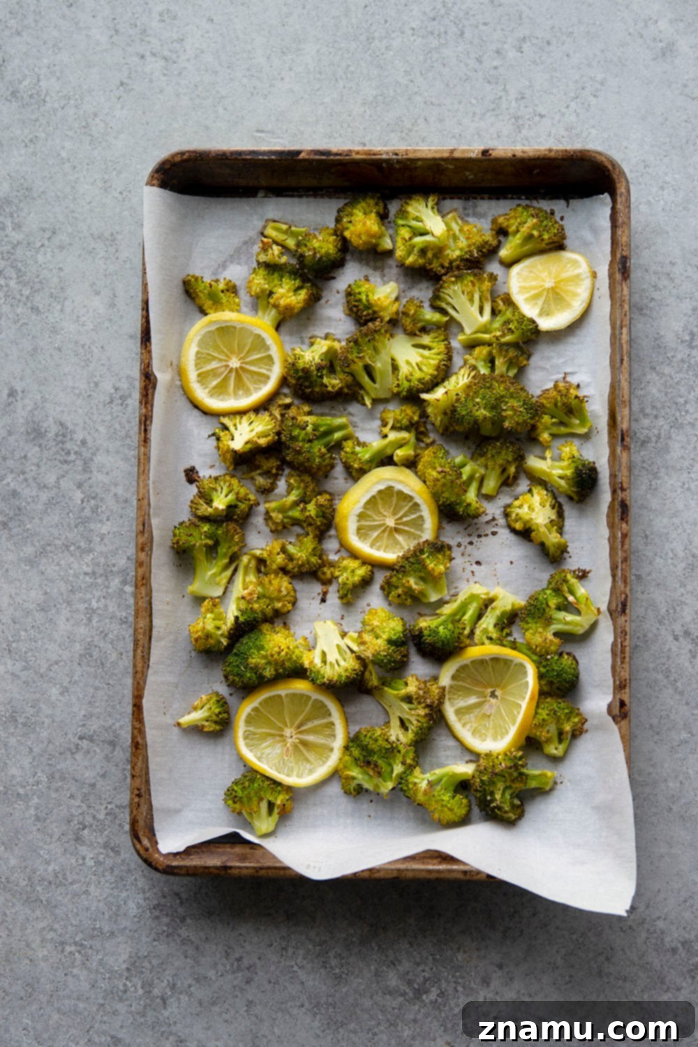 Zesty Roasted Broccoli Tortellini 4 Ingredients for Lemon Roasted Broccoli Tortellini laid out on a kitchen counter: fresh lemon, broccoli florets, cheese tortellini, olive oil, butter, garlic, and Parmesan.