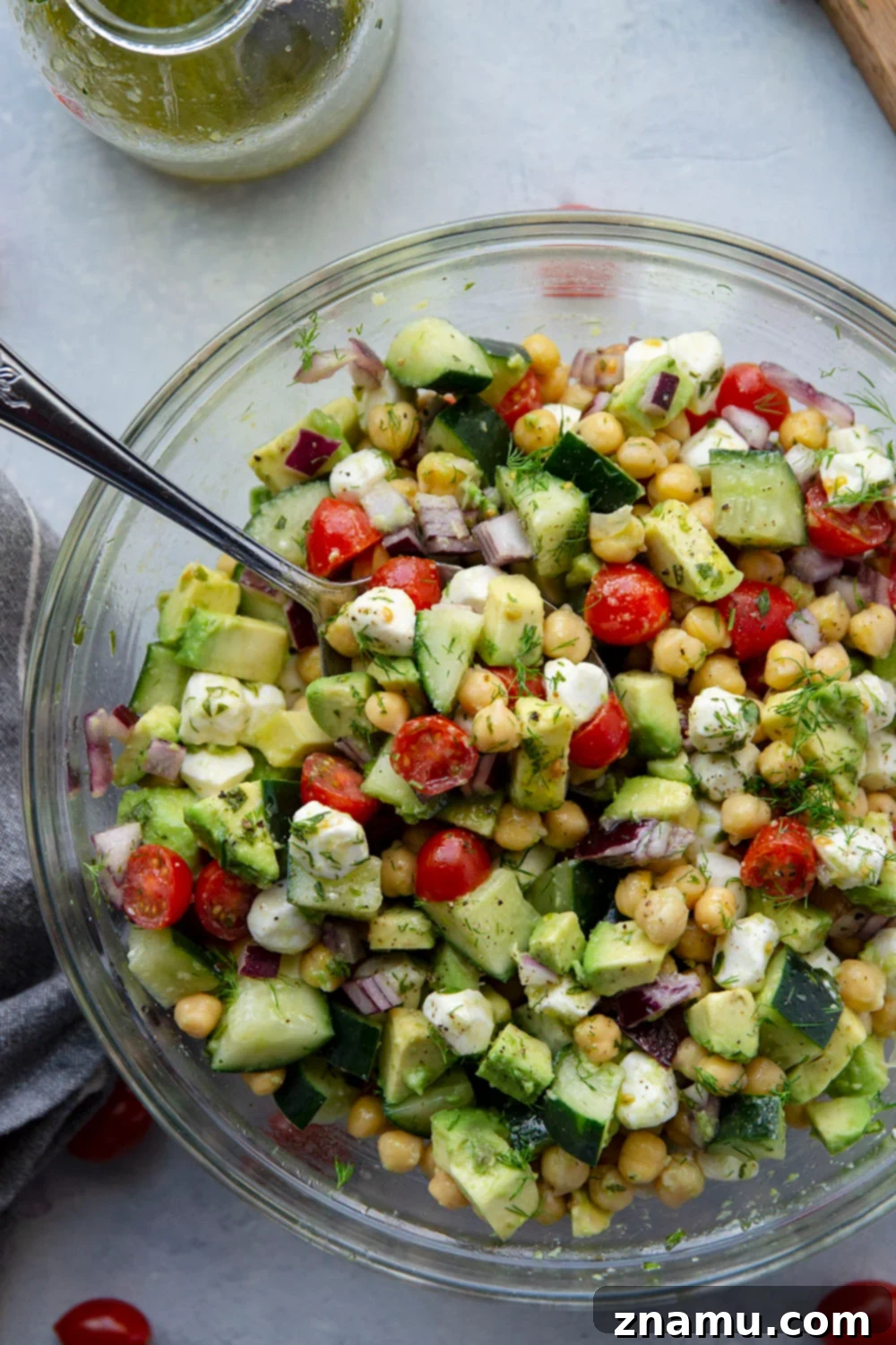 Creamy Italian Avocado Chickpea Salad 5 A large serving bowl filled with Italian Avocado Chickpea Salad, showcasing its abundance of fresh ingredients, ready to be served. The vibrant colors and textures are prominent.