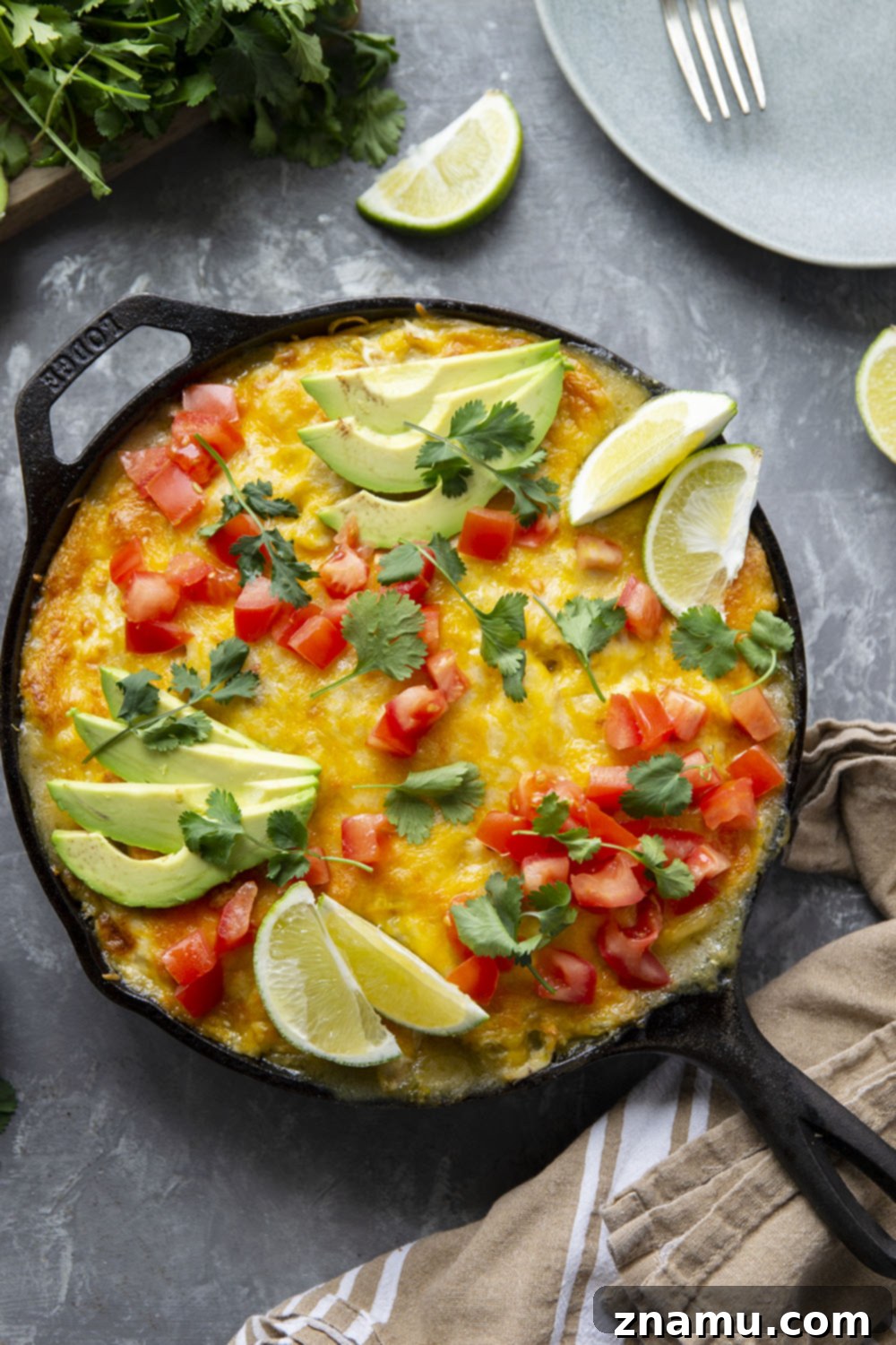 A golden-brown skillet green chile chicken enchilada casserole, bubbling with cheese and ready to be served, making it the perfect easy weeknight dinner.
