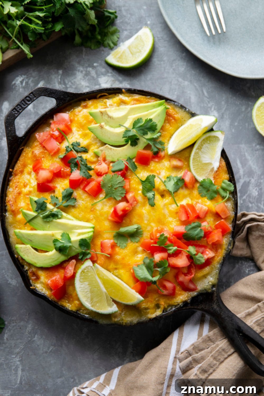 A close-up view of the rich, creamy green chile chicken filling, featuring tender shredded chicken, sweet corn, and a blend of savory spices, layered within a skillet enchilada casserole.