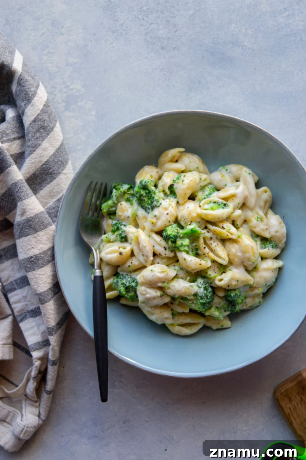 Creamy White Cheddar Broccoli Shells 4 Overhead shot of White Cheddar Broccoli and Shells in a large bowl, garnished with fresh parsley.