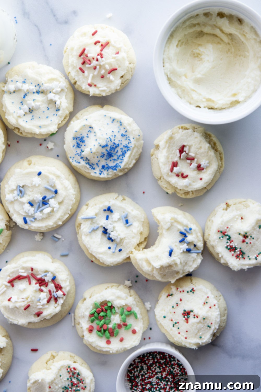 Pillowy Soft Chewy Sugar Cookies 4 An array of sugar-free cookies, some plain and some with a delicate pink icing, arranged appealingly.