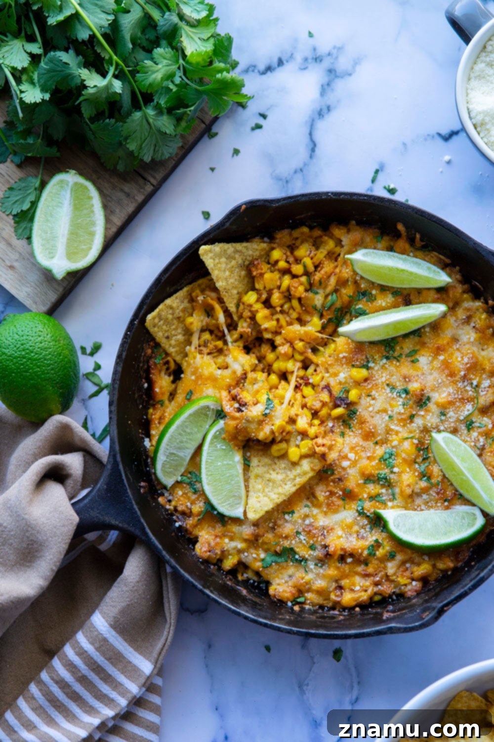Smoky Chipotle Elote Dip 2 A vibrant close-up of Chipotle Mexican Street Corn Dip, topped with fresh cilantro and lime, ready to be scooped with tortilla chips. This hot, cheesy appetizer features sweet corn, smoky chipotles, and gooey cheese.
