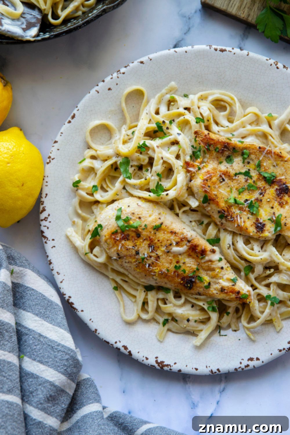 Creamy Lemon Pepper Chicken Alfredo Fettuccine 3 Close-up of creamy lemon pepper chicken alfredo pasta with fresh parsley garnish.