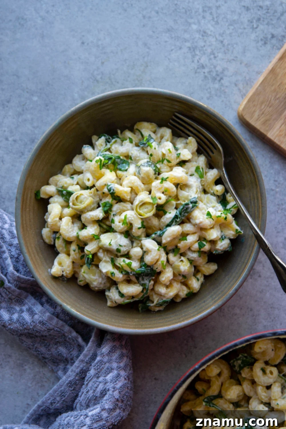 Effortless One-Pot Spinach Artichoke Pasta 3 Close-up of creamy One-Pot Spinach Artichoke Pasta, showcasing melted cheese and fresh spinach.